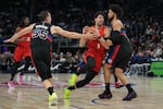 Portland Trail Blazers forward Deni Avdija, center, drives against Detroit Pistons forward Duncan Robinson, left, and guard Cade Cunningham during the first half of an NBA basketball game, Friday, Dec. 5, 2025, in Detroit.