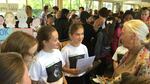 Brooke Abbruzzese (reading from page) and Talia Baskin (red ponytail band) present the girls’ “Saving Pan” cookbook project to Dr. Jane Goodall during a Roots & Shoots event at David Douglas High School in Portland, Oregon, on Oct. 15, 2015. In early 2018, they donated $10,000 from its sales to benefit Goodall’s chimpanzee rehabilitation center and sanctuary in the Republic of Congo.