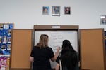Hillsboro City Council candidates Diana Jackson and Dorian Russell write on a whiteboard with candidate names.