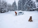 Jason Arbetter of Bend shovels out a spot for a car that got stuck trying to travel down First Street on February 25, 2019. 