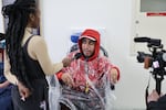 Rick Macias is a young man in a wheelchair; he's wearing a rain poncho. He's speaking to a reporter who is holding a microphone to his face. They are in a hallway of a congressional building.