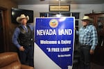 Ryan Bundy, left, and Cliven Bundy hold up a sign in their living room. Ryan Bundy is running for governor as a next step in the family's fight to remove the federal government from Nevada.