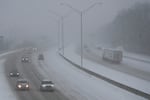 Vehicles drive along a highway during a winter storm, Sunday, Jan. 5, 2025, in Cincinnati.