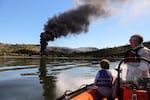 Chris Hooper, right, of White Salmon watches the fire caused by a derailed oil train in Mosier, Oregon, near Hood River in the Columbia River Gorge on Friday, June 3, 2016.