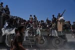 Palestinians hold onto an aid truck returning to Gaza City from the northern Gaza Strip, Sunday.