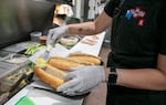 Lisa Tran prepares an order of bánh mì sandwiches at Tân Tân Café and Delicatessen in Beaverton, Ore., June 13, 2025. Tân Tân is known for their specialty meats like pâté, meatballs and ham. 