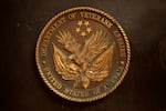 A plaque depicts the Department of Veterans Affairs' seal with an eagle clutching two flags in its talons and five stars above the eagle.