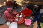 A woman gives a baby a bath inside a tent at a camp for displaced Palestinians in Rafah on Jan. 18.