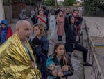 People gather outside a residential building damaged during Russian drone attacks on May 30, 2023 in Kyiv, Ukraine. At least one person was killed in an early Tuesday strike, the Kyiv mayor said.