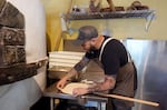 Chef Vincent Krone of Ken’s Artisan Pizza in Portland, Ore. stretches pizza dough onto a pizza peel, Aug. 7, 2024. Ken’s saw a 40% increase in sales from 2022 to 2024.