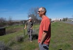 Josh Walton and his son Blake Walton talk to neighbors at their home in Umatilla, Ore., in April 2026. The Waltons say the new data center adjacent to their property emits bright lights at night and a loud humming, especially on hot days — both of which disrupt their sleep.