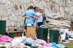 An officer prays with a family as they pick up items at Camp Mystic in Hunt, Texas, on July 9.