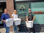 Tiffany Hammer, center, and an Echelon Security employee, right, joined with Union Gospel during the heat wave to help folks relocate to shelters and cooling centers, and hand out water. Hammer envisioned a new model of private security — guards actively patrolling the area, protecting businesses while also assisting the people living in tents outside them.