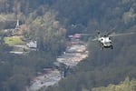 Marine One, carrying President Joe Biden, flies above a storm impacted area near Asheville, North Carolina on October 2, 2024. Biden was visiting North and South Carolina to survey the damage after the passage of Hurricane Helene. Social media sites, especially X, were filled with politically-charged rumors and conspiracy theories about the hurricane response.