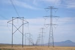 Electrical transmission lines run through grass lands to power Meta's Facebook data center in Eagle Mountain, Utah. The data center is a complex of five large buildings each over four football fields long and totaling 2.4 million square feet.