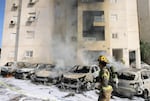 Israeli fire brigade teams douse the blaze in a partking lot outside a residential building following a rocket attack from the Gaza Strip in the southern Israeli city of Ashkelon.