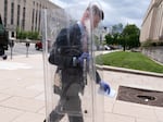 A government official carries a police shield used as evidence against Dominic Pezzola from federal court in Washington, Thursday, May 4, 2023.