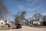 Smoke rises from the derailed train on Feb. 4, the day after the crash.