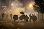 Tear gas fills the air during protests, Friday, Sept. 18, 2020, in Portland, Ore. The protests, which began over the killing of George Floyd, often result frequent clashes between protesters and law enforcement.