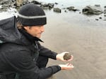 Travis Williams, executive director of Willamette Riverkeeper, holds sand from the banks of the Willamette River in the Portland Harbor. 