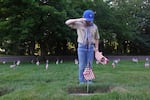 Anderson Voigt, 11, of Canby salutes at the grave of a World War II veteran. The scouts place 130,000 flags at Willamette National Cemetery in honor of Memorial Day.
