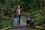 Bo Mullan goes for a walk with Cosmo, his girlfriend's dog, in Portland, Ore., on March 4, 2026.