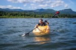 Gary Kristensen paddles a giant pumpkin boat down the Columbia River on May 23, 2025.