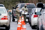 National Guard personnel check in people as they wait to receive a COVID-19 vaccination Feb. 26, 2021, in Shelbyville, Tenn. Tennessee has continued to divvy up vaccine doses based primarily on how many people live in each county, and not on how many residents belong to eligible groups within those counties.