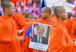 A Cambodian Buddhist monk holds a portrait of President Trump as he takes part in a march for peace in Phnom Penh on Aug. 10, following a border conflict with Thailand.