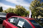 Daniel Shea, president of the local chapter of Veterans For Peace, decorates his vehicle for a May Day car caravan in Portland, Ore., Friday, May 1, 2020. Organizers at in-person and virtual rallies called for more personal protective equipment and hazard pay for essential workers.