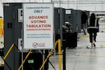 An election worker walks near voting machines at the Fulton County Election Hub and Operation Center, Tuesday, Nov. 5, 2024, in Atlanta.
