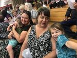 Julie Thompson (center) talks to her 4-year-old niece Charisma as they share bleacher seats with Charisma's mom, Merissa Biggs, and her 2-year-old brother Keeneye, Sunday, July 28, 2019. They were among 500 people who attended a community meeting on the fast-moving Milepost 97 Fire.