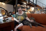 Miranda Krone and her cat Frankie sit in her apartment at the Everett Station Lofts in Portland, Ore., on Sept. 26, 2024. Krone is the lead plaintiff in a class action lawsuit against the complex's owners.