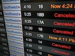 A digital display shows cancelled flights in the Southwest Airlines luggage area at Los Angeles International Airport in December 2022.