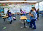 children standing at their desks in a classroom