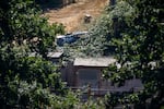 A burned vehicle sits on a property near Forest Grove, Ore., on Aug. 24, 2026, where five bodies were discovered the previous day after a vehicle fire.