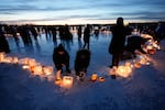 Activists gather in protest to light candles on frozen Lake Nokomis in Minneapolis, spelling, "Ice Out" on Jan. 31, 2026.