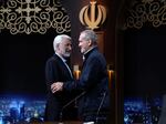 In this photo made available by Iranian state-run TV, IRIB, Iranian presidential candidate Saeed Jalili, left, a hard-line former nuclear negotiator, and reformist candidate Masoud Pezeshkian greet one another at the conclusion of a debate at the TV studio in Tehran, Iran, on June 1, 2024.
