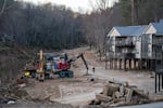 Construction vehicles are parked next to a storm-damaged apartment complex in a landscape scarred by Hurricane Helene near Swannanoa, N.C., on March 24.