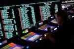 A person gambles as betting odds for NFL football's Super Bowl are displayed on monitors at the Circa resort and casino sports book Friday, Feb. 3, 2023, in Las Vegas.