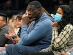 Former Seattle SuperSonics forward Shawn Kemp, center, was booked into jail Wednesday, on a felony charge stemming from a shooting. He's seen here last year, at a WNBA game between the Seattle Storm and the Chicago Sky.