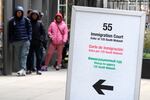 People wait in a line before being led into a downtown Chicago building where an immigration court presides on Nov. 12, 2024, in Chicago. (AP Photo/Charles Rex Arbogast)