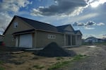 A house with a pile of gravel in the front yard.