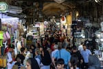 People walk past shops and browse for goods at the Grand Bazaar in Tehran on Aug. 24.