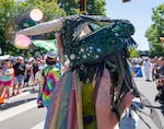 An attendee of the Portland Pride parade dances to music as they move along the parade route.