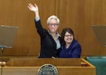 Gov. Tina Kotek waves to the crowd, along with her wife, Aimee Kotek Wilson, after being sworn into office at the Oregon Capitol in Salem, Ore., Jan. 9, 2023.