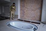 LATAKIA, Syria, 01/05/25 An HTS fighter beside the hot tub of former Syrian President Bashar al-Assad in his family villa outside Latakia. After the fall of the Assad regime in Syria, the family's properties were left abandoned. One of those was the Assad family's summer home, with a private beach on the Mediterranean. Ayman Oghanna for NPR