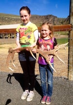 Kyra and Bobbi Cline, 11 and 7, hold up an elk antler they found.