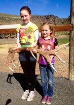 Kyra and Bobbi Cline, 11 and 7, hold up an elk antler they found.