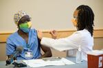 Cardiovascular intensive care nurse Ansu Drammeh was first in line to receive an injection of the Pfizer BioNTech vaccine at Oregon Health & Science University on Wednesday, Dec. 16, 2020. The shot was administered by  dental resident Ryan Thrower.